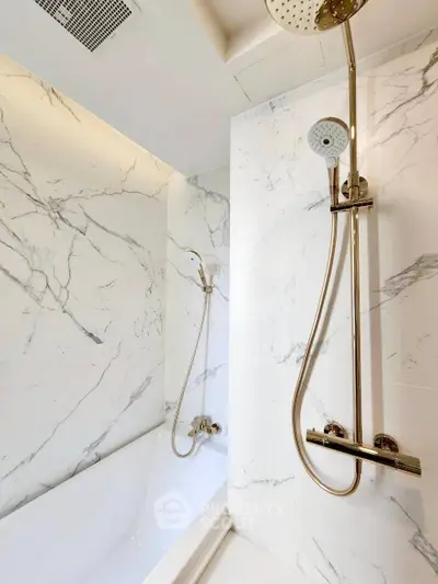 Luxurious bathroom with elegant marble walls and modern shower fixtures.