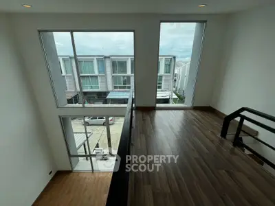 Modern duplex interior with large windows and wooden flooring, offering a bright and airy atmosphere.