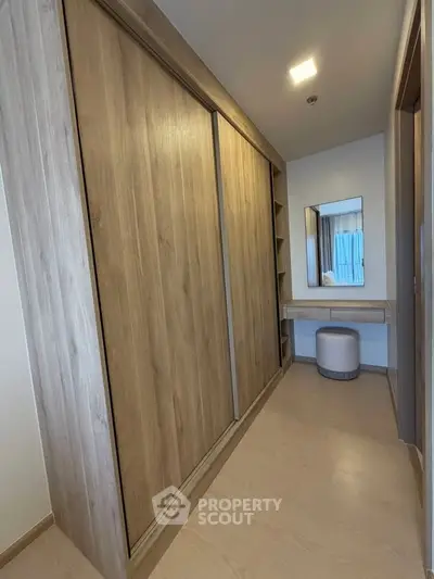 Spacious walk-in closet with wooden sliding doors and a vanity area, perfect for organized storage.