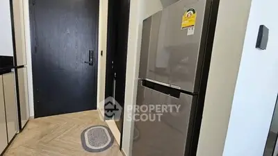 Modern kitchen entrance with sleek refrigerator and stylish flooring