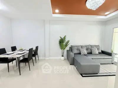 Modern living room with stylish gray sofa and elegant dining area