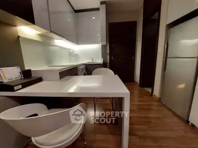 Modern kitchen with sleek white cabinets and integrated appliances in a stylish apartment.