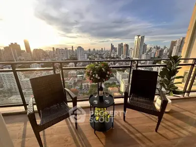 Stunning cityscape view from a high-rise balcony with elegant seating and lush plants.