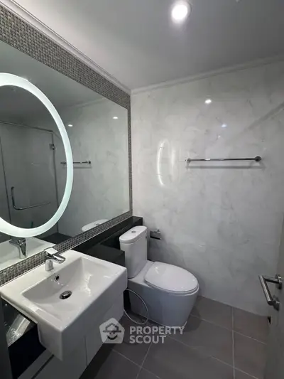 Modern bathroom with sleek fixtures and illuminated mirror