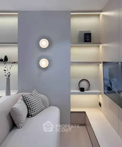 Modern living room with stylish shelving and cozy sofa, featuring elegant lighting and decorative accents.