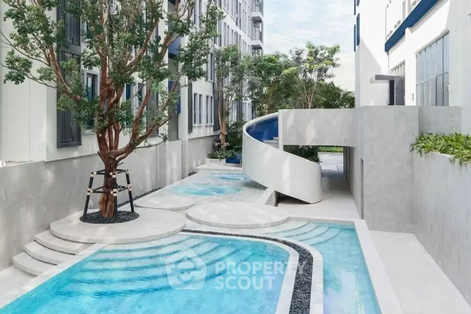 Modern apartment complex with stylish pool and spiral staircase