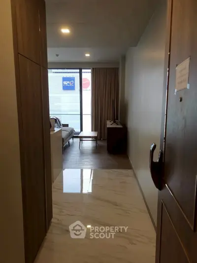 Modern apartment entrance leading to a cozy living room with natural light.