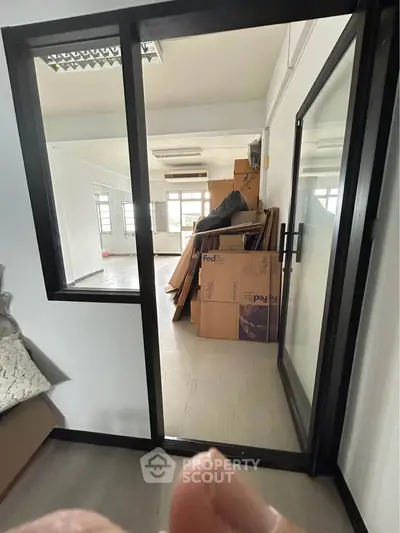 Spacious storage room with glass sliding door and FedEx boxes, ideal for organizing and maximizing space.