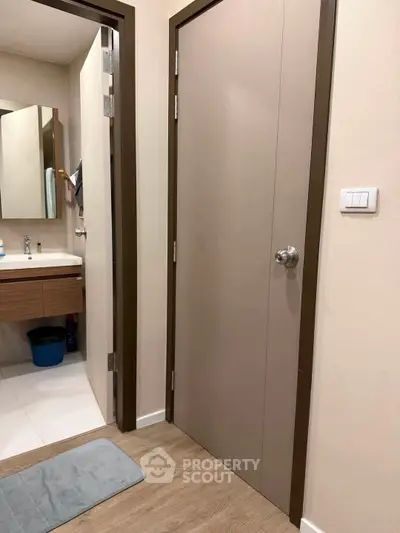 Modern bathroom entrance with sleek design and wooden flooring