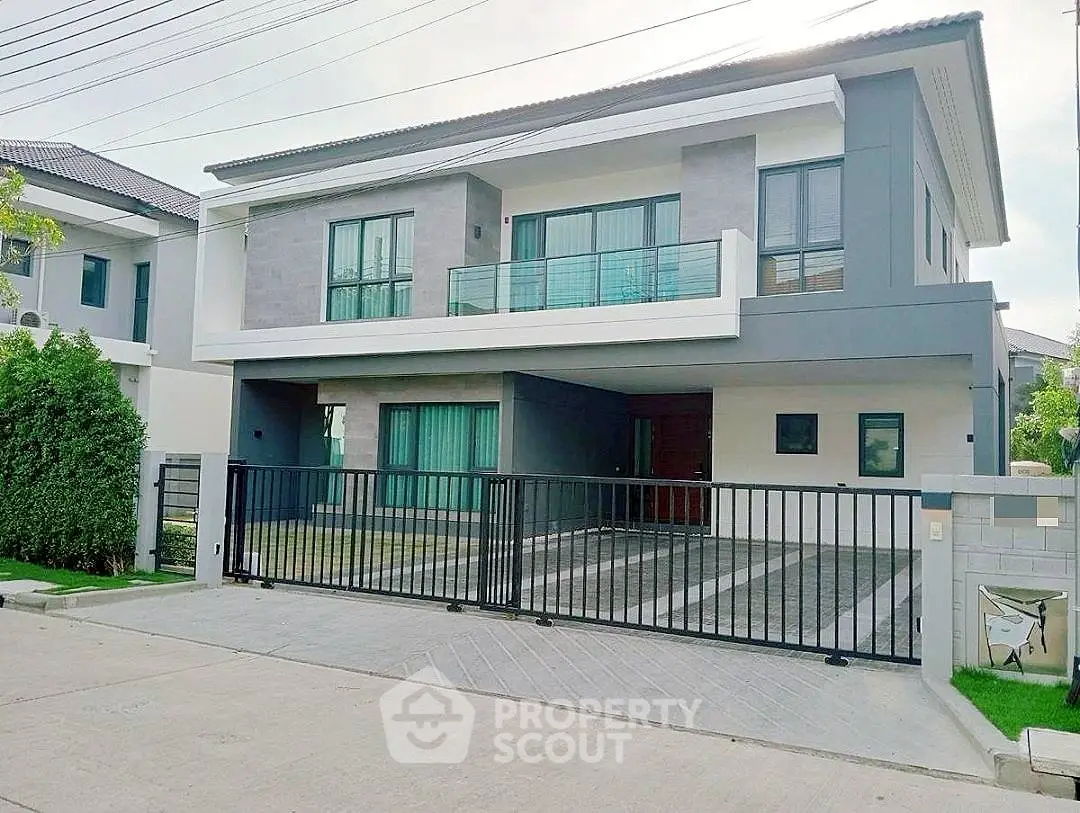 Modern two-story house with sleek design and spacious driveway in a suburban neighborhood.