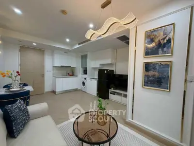 Modern living room with open kitchen, stylish decor, and cozy seating area in a contemporary apartment.