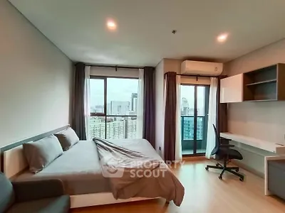 Modern bedroom with city view, featuring a cozy bed and study area, ideal for urban living.