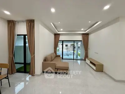 Spacious modern living room with large windows and elegant furnishings