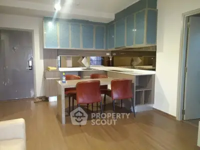 Modern kitchen with sleek cabinetry and dining area in stylish apartment.