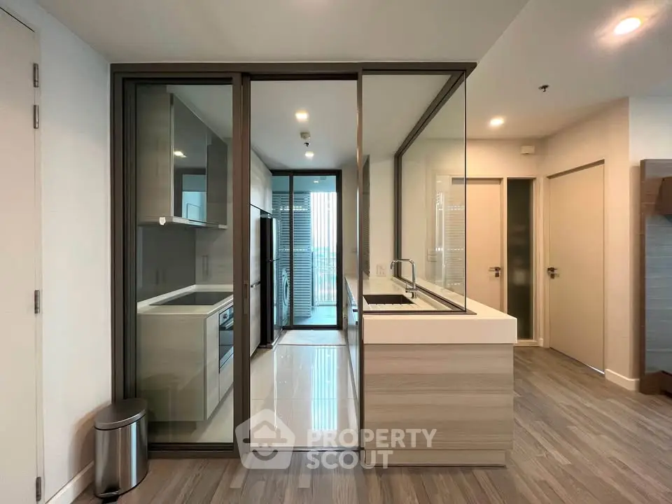 Modern kitchen with sleek design and glass partition in a contemporary apartment.