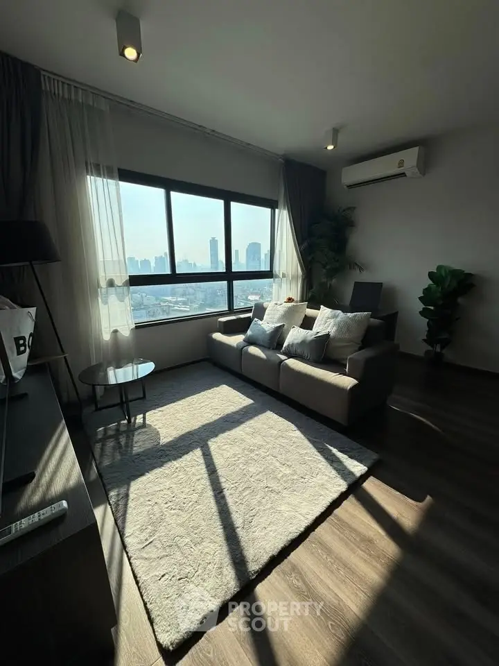 Modern living room with city view, stylish decor, and ample natural light.