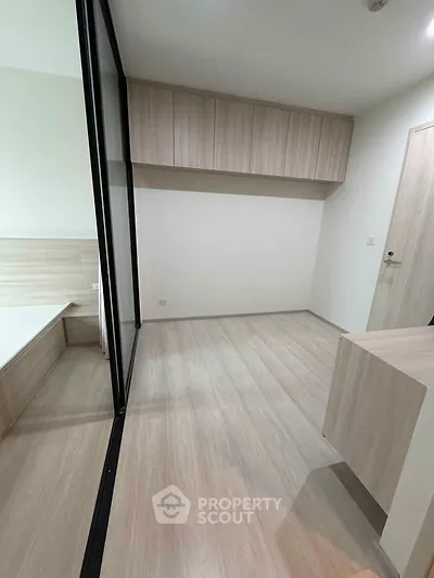 Modern minimalist bedroom with wooden flooring and built-in storage cabinets