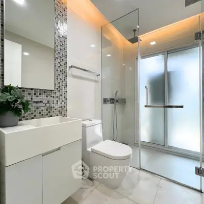 Modern bathroom with sleek design, glass shower, and stylish fixtures.