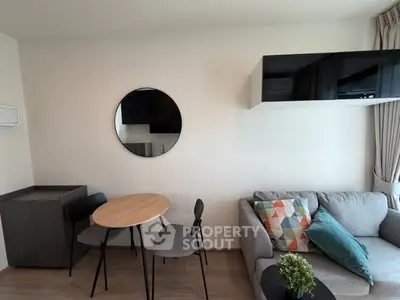 Modern living room with stylish furniture and decor, featuring a cozy sofa and round dining table.