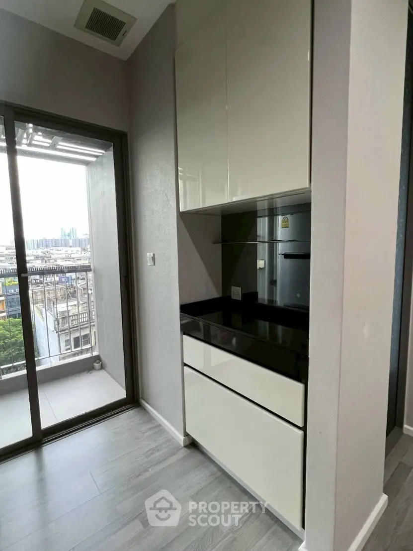 Modern kitchen with sleek cabinetry and balcony view in urban apartment