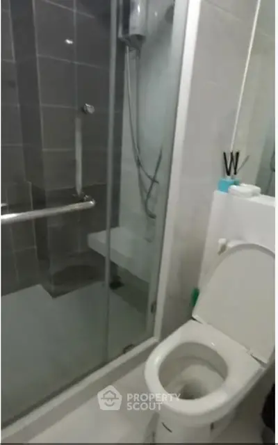 Modern bathroom with glass shower enclosure and sleek toilet design.