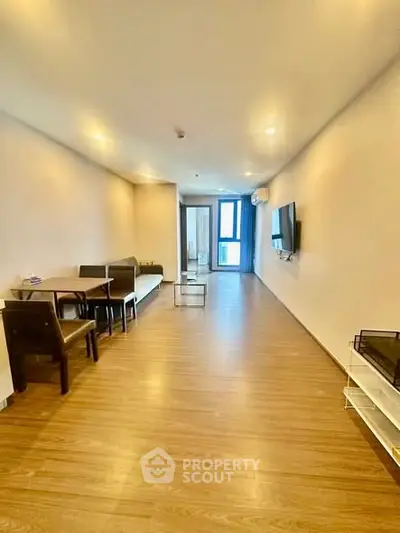 Spacious modern living room with wooden flooring and wall-mounted TV