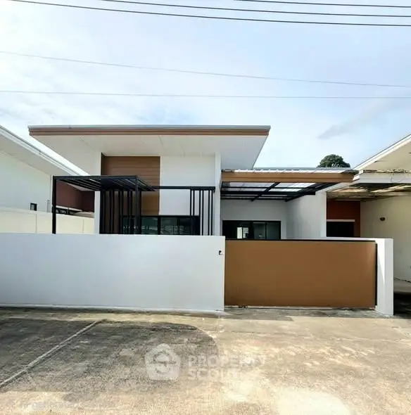 Modern single-story house with sleek design and spacious driveway in a serene neighborhood.