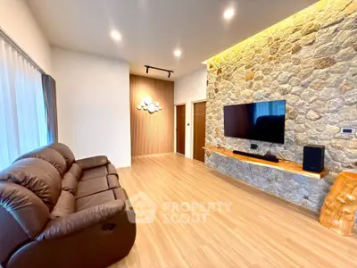 Modern living room with stone accent wall, sleek wooden flooring, and cozy leather sofa.
