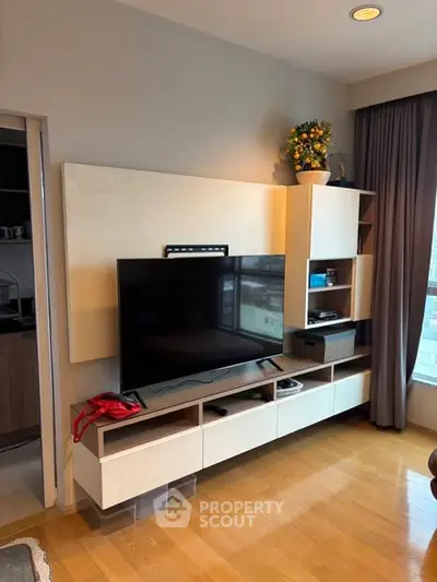 Modern living room with sleek entertainment center and large window view
