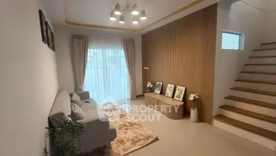 Modern living room with stylish decor and staircase in a cozy home setting.