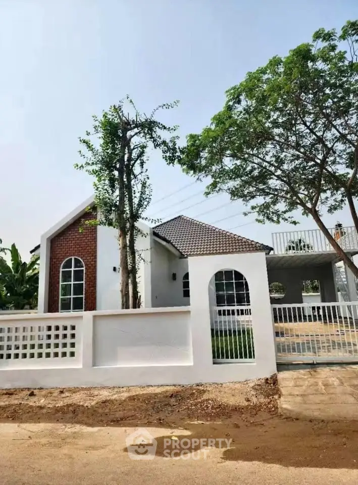 Charming single-story house with brick accents and lush greenery, perfect for serene living.