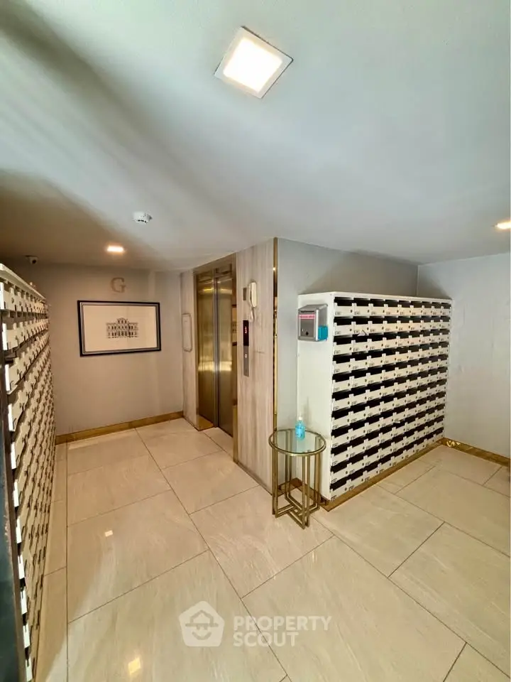 Modern apartment building entrance with mailboxes and elevator access.