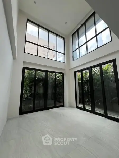 Spacious modern living room with high ceilings and large windows