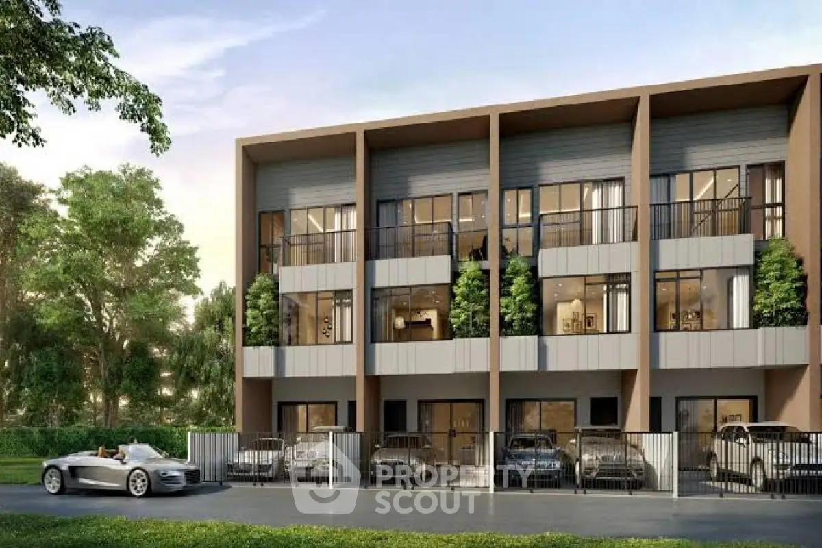 Modern townhouse exterior with multiple balconies and parked cars, surrounded by greenery.
