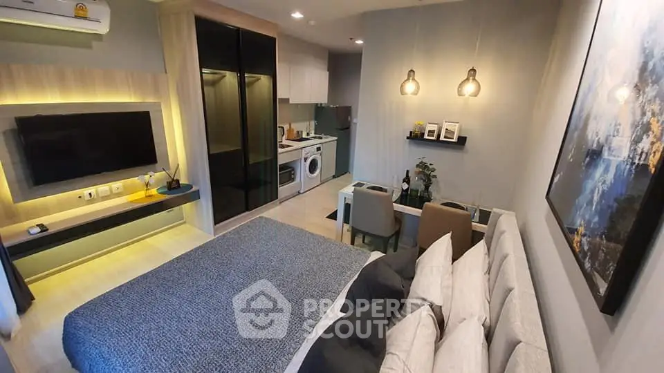 Modern studio apartment with cozy living area, stylish kitchen, and elegant decor.