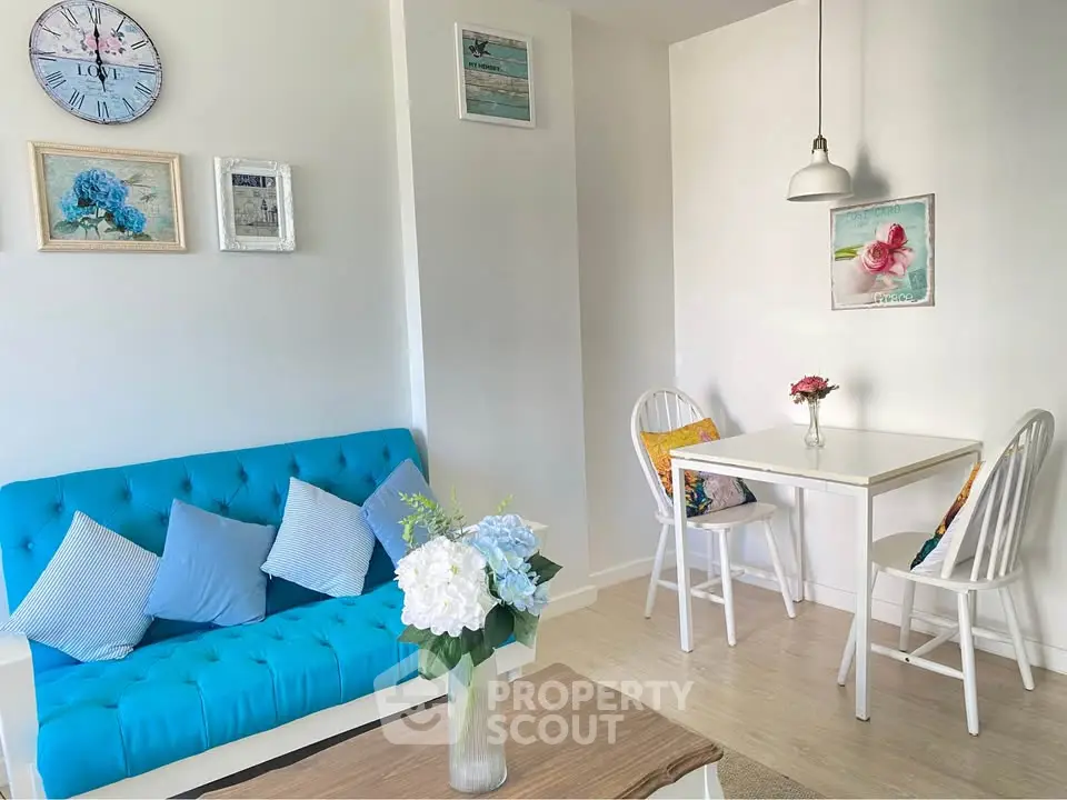 Charming living room with vibrant blue sofa and cozy dining area, perfect for modern living.