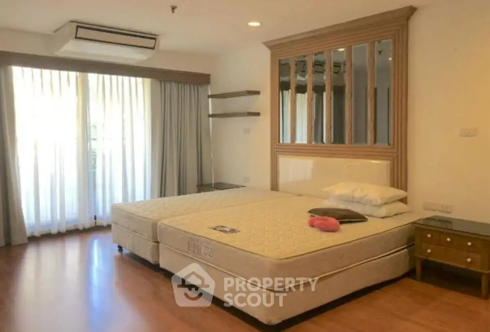 Spacious bedroom with large windows and modern decor in a luxury apartment.