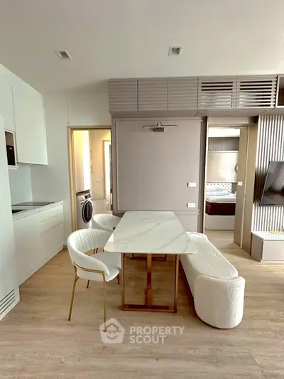 Modern open-plan living area with stylish dining set and sleek kitchen design