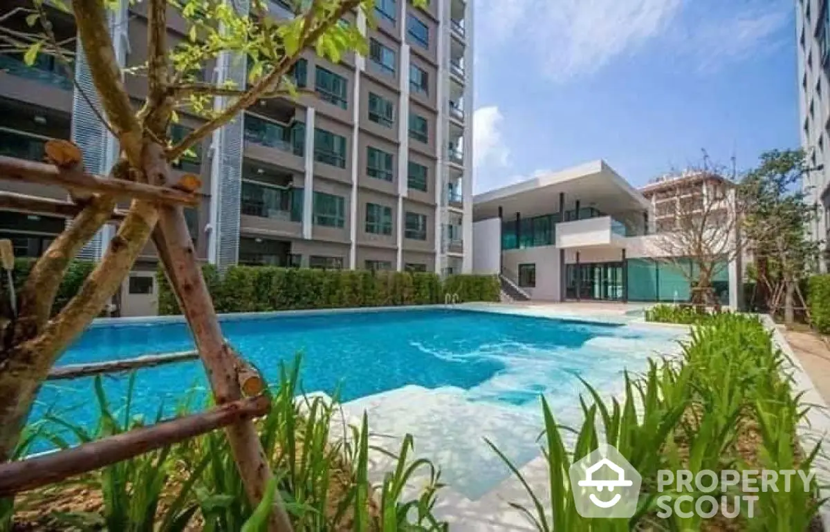 Modern apartment complex with a luxurious swimming pool and lush greenery.