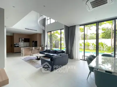 Luxurious open-plan living room with pool view, modern kitchen, and elegant furnishings in a contemporary home.