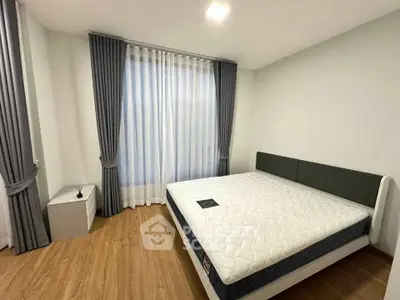 Spacious bedroom with modern decor and large window for natural light