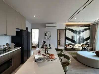 Modern open-plan kitchen and living room with stylish decor and natural light.