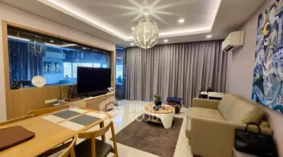 Modern living room with stylish decor, large TV, and cozy seating area in a contemporary apartment.