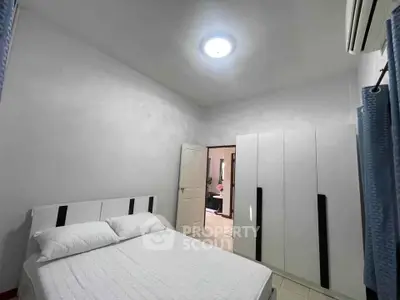 Spacious bedroom with modern white furniture and air conditioning
