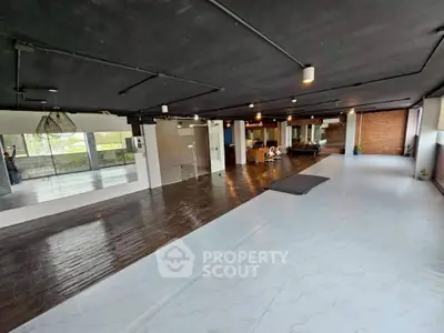 Spacious open-plan interior with modern design and wooden flooring, ideal for versatile use.