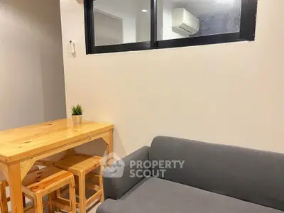 Cozy living room with wooden dining set and modern gray sofa