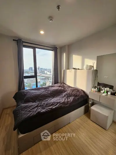 Cozy bedroom with city view, featuring a comfortable bed and modern decor, perfect for urban living.