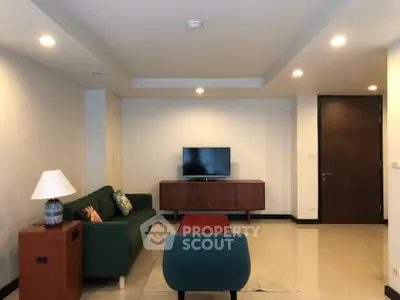 Spacious living room with modern furniture and TV, ideal for relaxation and entertainment.