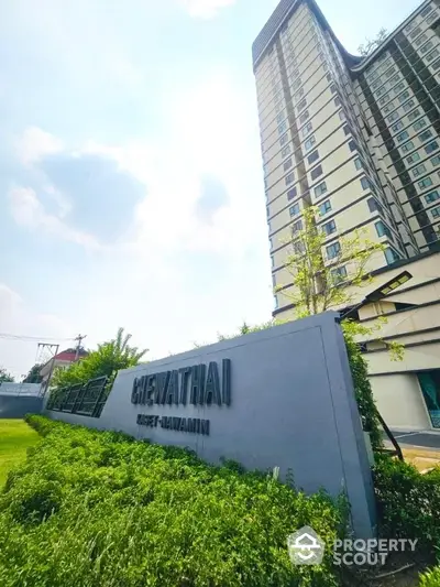 Modern high-rise building with lush greenery at Chewathai Kaset-Nawamin.