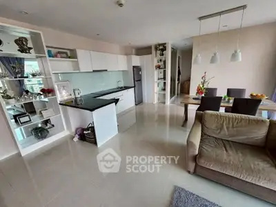 Modern open-plan living room and kitchen with sleek design and ample natural light.